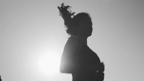  a young woman jogging in front of the sun 